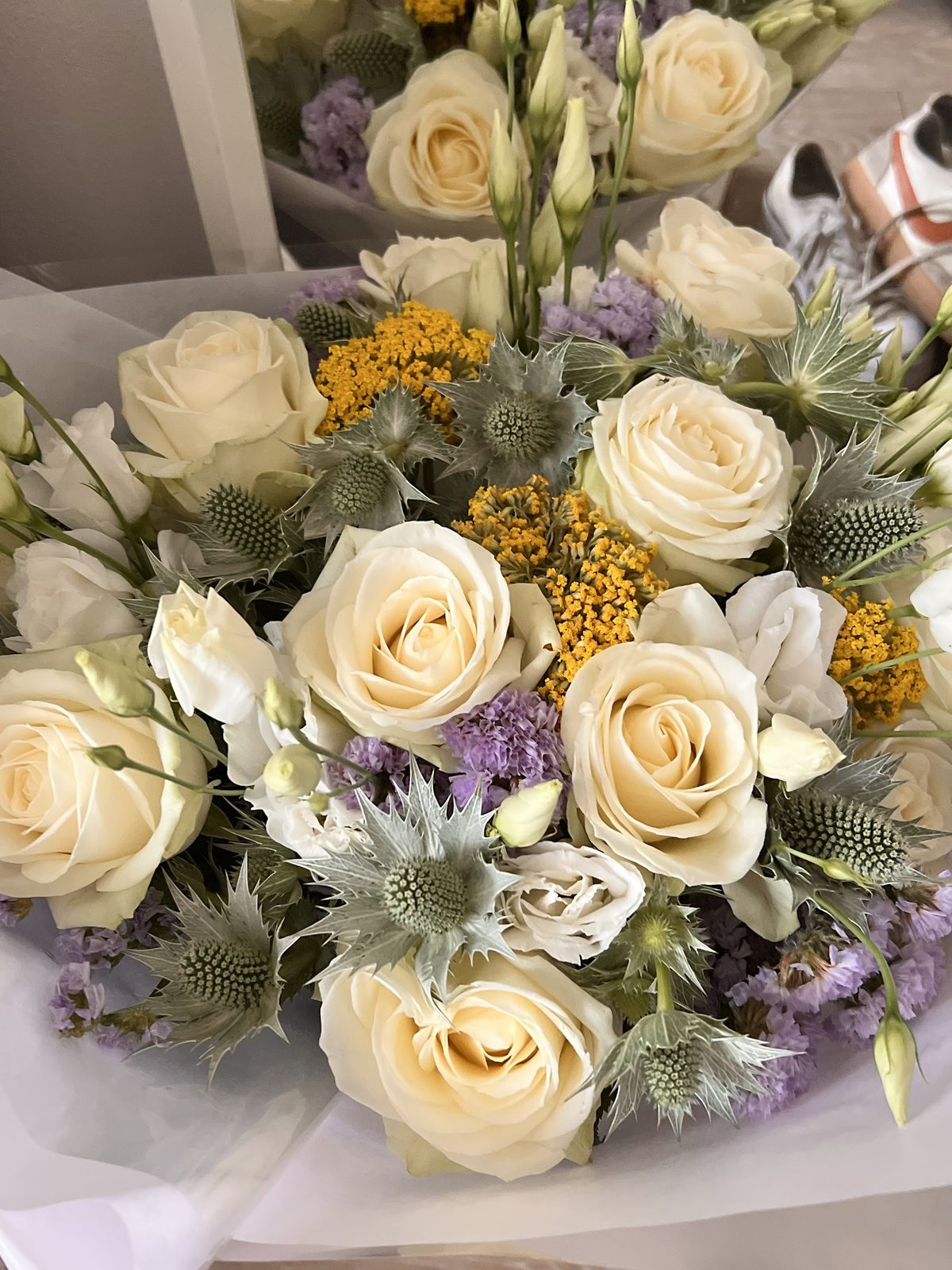 Bouquet de roses blanches, chardons et feuillage argenté