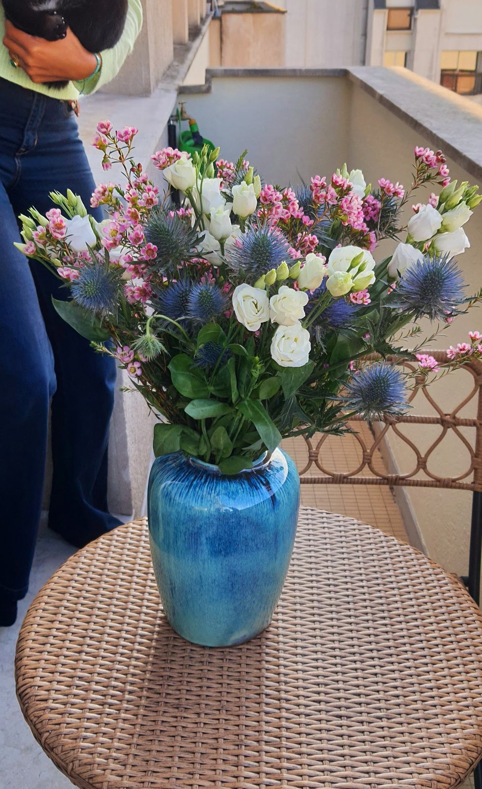 Bouquet de chardons bleus et fleurs blanches dans un vase bleu